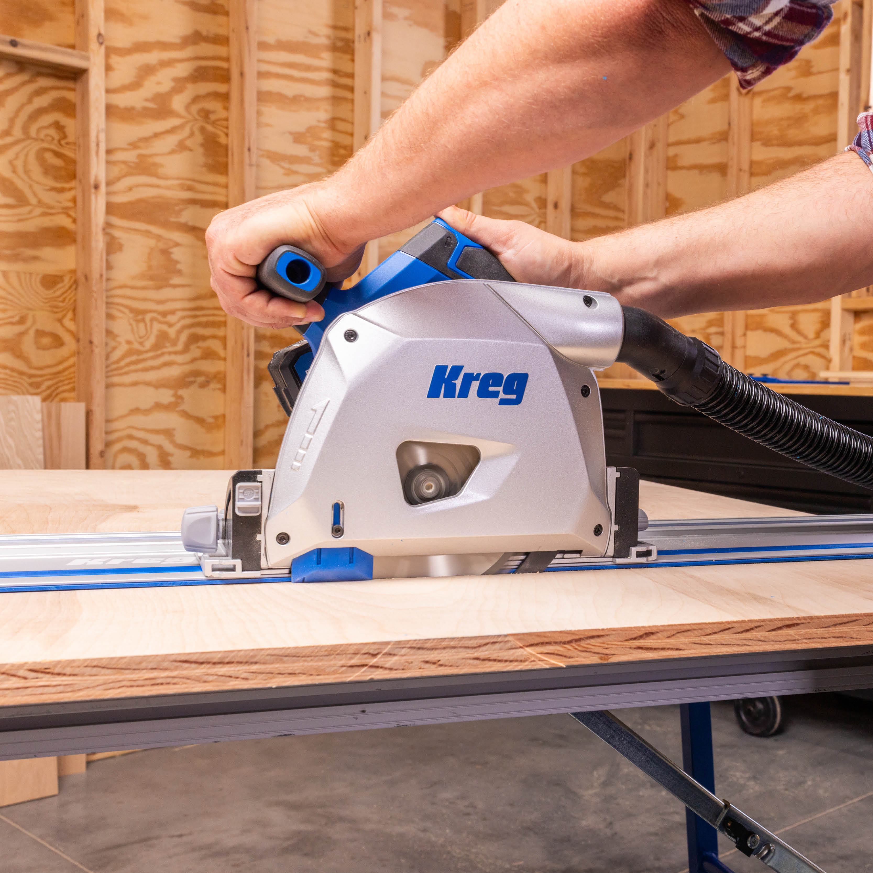 A hero shot of the Kreg track saw cutting through a sheet of plywood. 