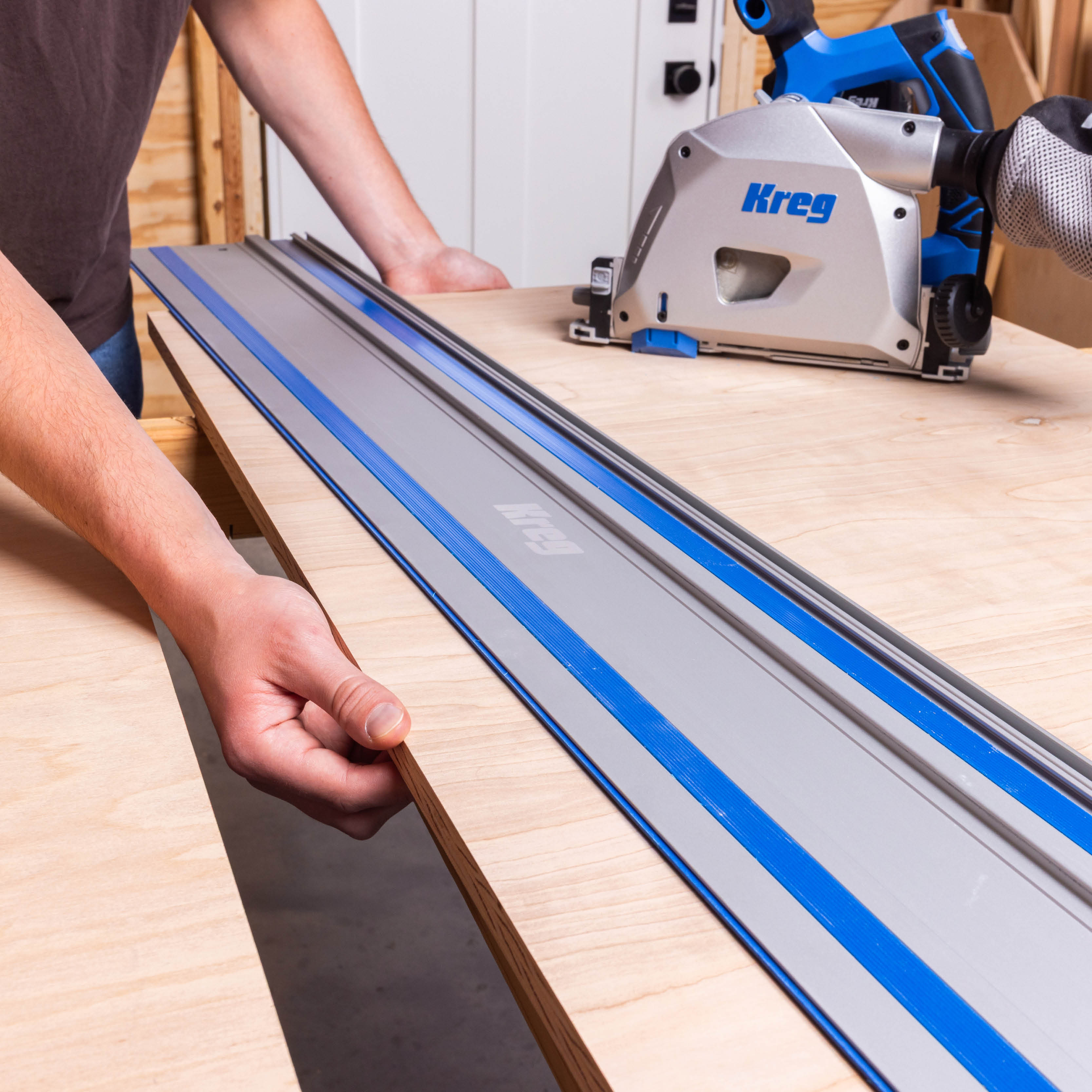 A man adjusts his workpiece under his Kreg track saw. 