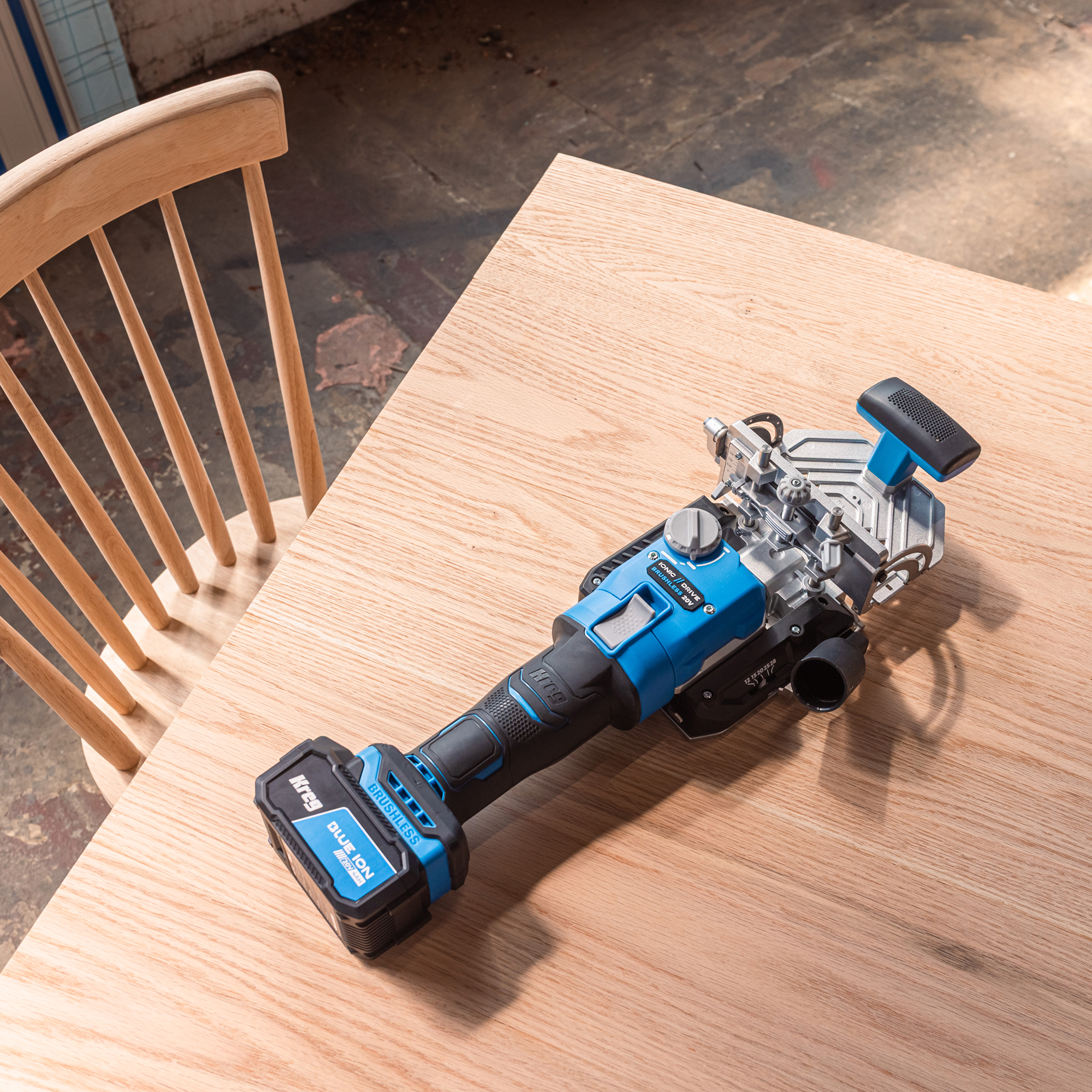 The Kreg Edge loose tenon joiner is laying on a table next to a wooden chair