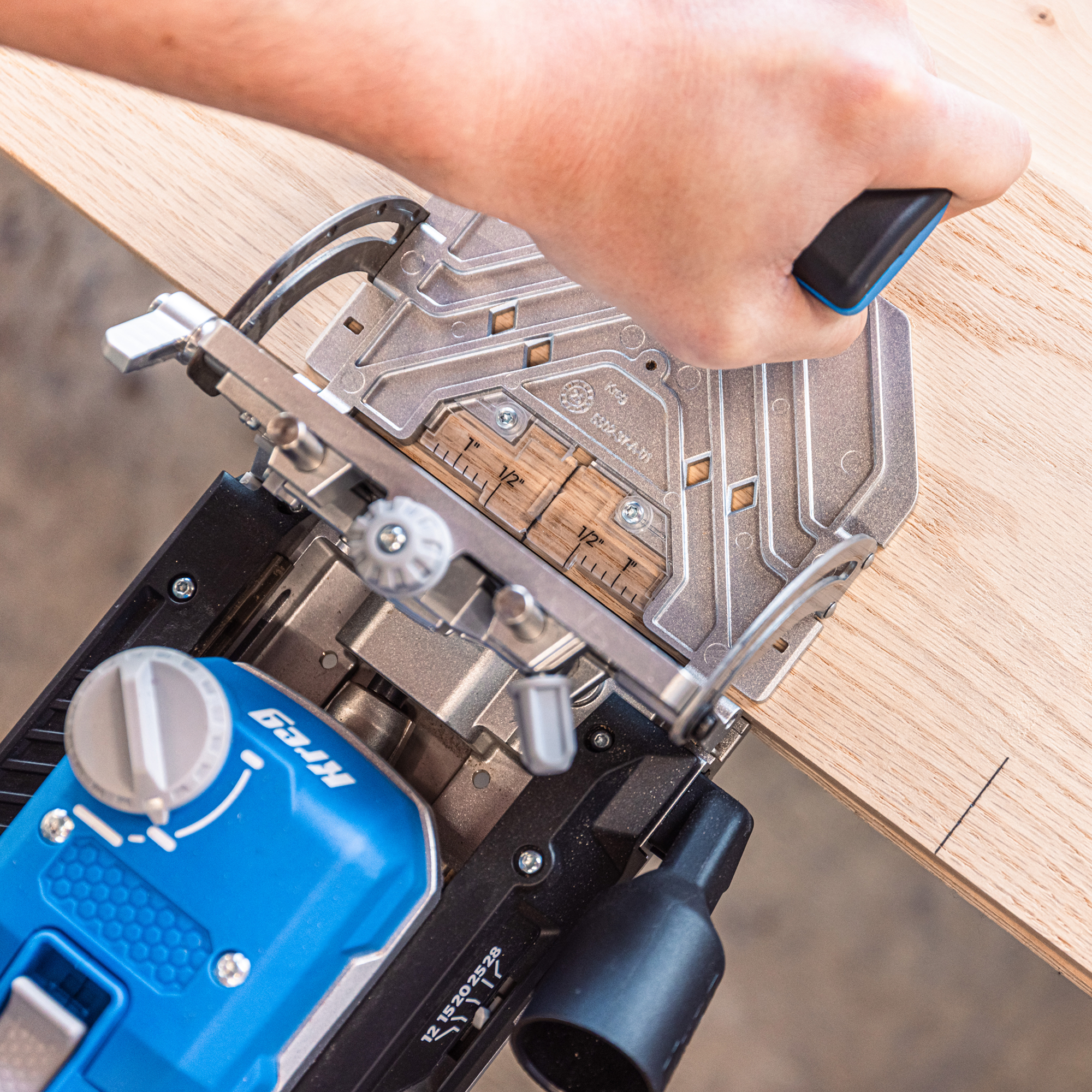 A hand is grasping the Kreg Edge as a mortise is being drilled into plywood.