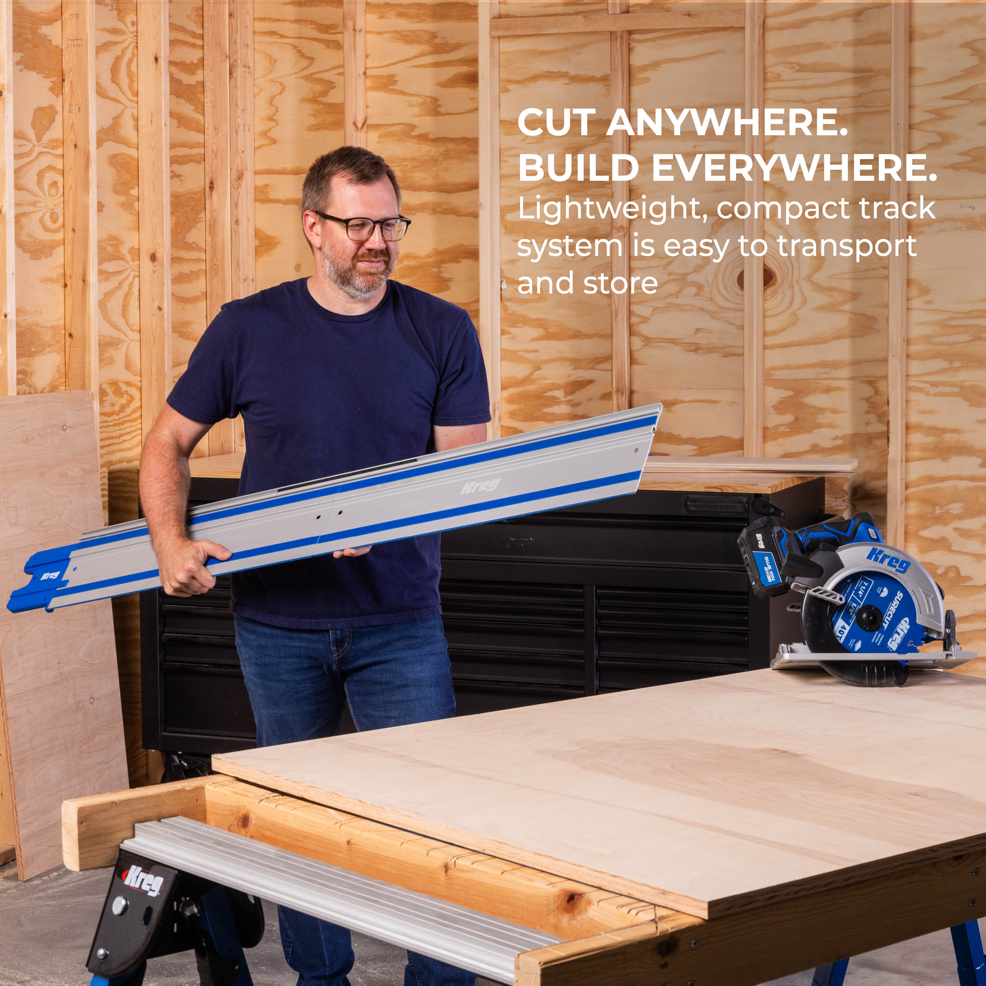A man carries his Kreg Universal Track to a temporary workbench. His Kreg Circular Saw sits on top of the bench. Caption - "Cut anywhere. Build everywhere. Lightweight, compact track system is easy to transport and store. 