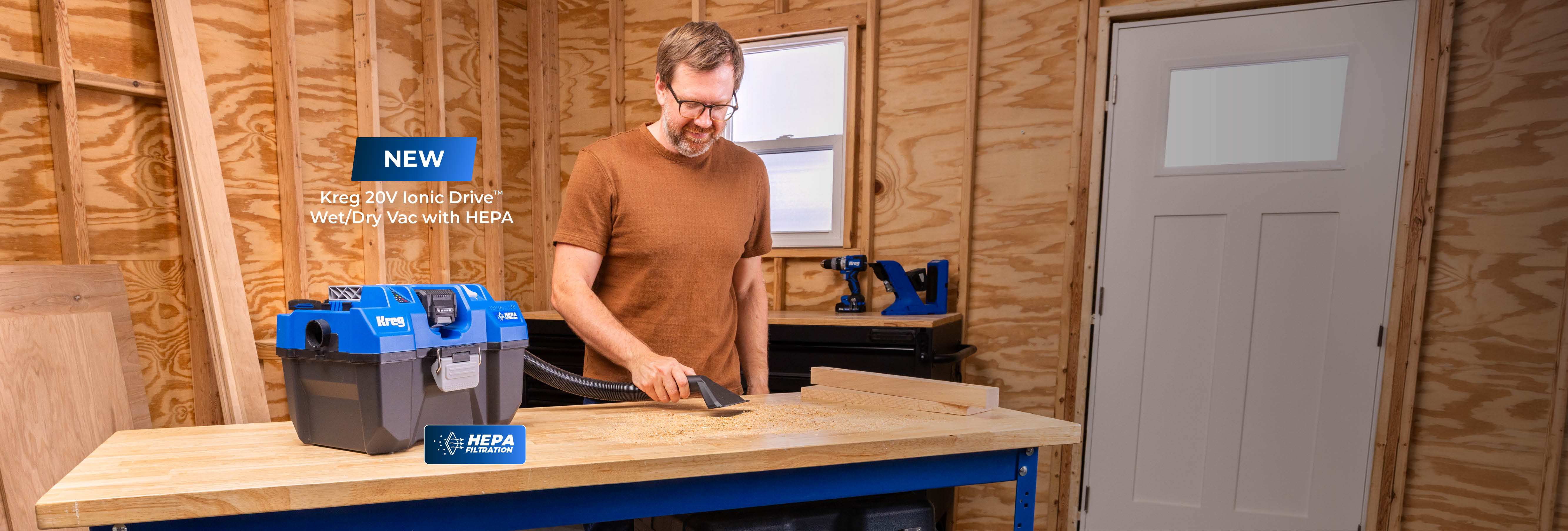 A man vacuums his workbench with the Kreg Ionic Drive Wet/Dry Vacuum.